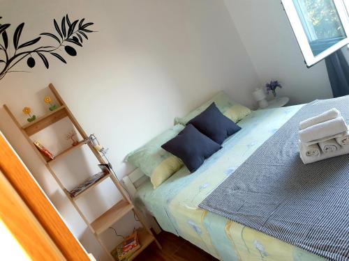 a small bedroom with a bed with blue pillows at Apartments Ines in Orebić