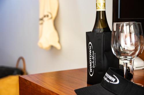 a bottle of wine and a glass on a table at Windtown Lagoon Hotel in Langebaan