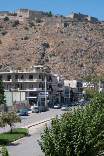 a city street with cars parked in front of a mountain at apt.27-103 in Nafplio