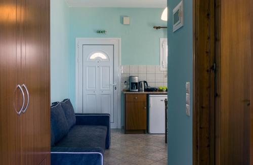a living room with a blue couch and a kitchen at Kaskanis Apartments in Vráchos