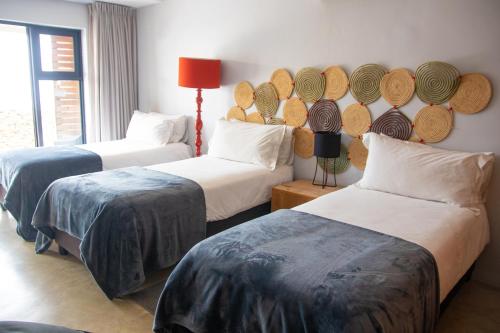 a room with two beds with hats on the wall at Windtown Lagoon Hotel in Langebaan
