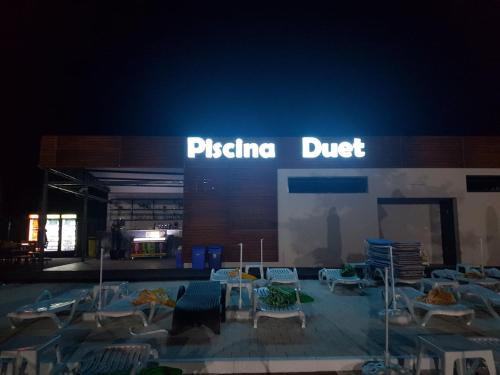 a store with chairs and tables in front of a building at Pensiunea Duet in Sărata-Monteoru