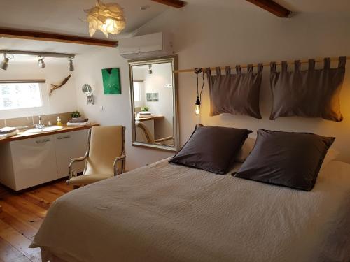 1 dormitorio con cama con espejo y lavamanos en Caseddu Di Poggiale, en Figari
