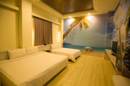 ein Schlafzimmer mit 2 Betten und ein Strandgemälde in der Unterkunft Anshun Hotel in Taichung