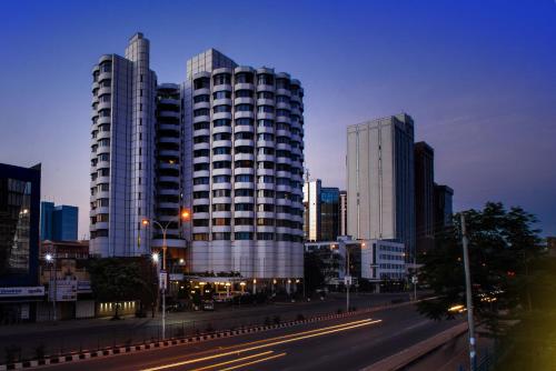 a city with tall buildings and a street with cars at Nairobi Safari Club by Swiss-Belhotel in Nairobi