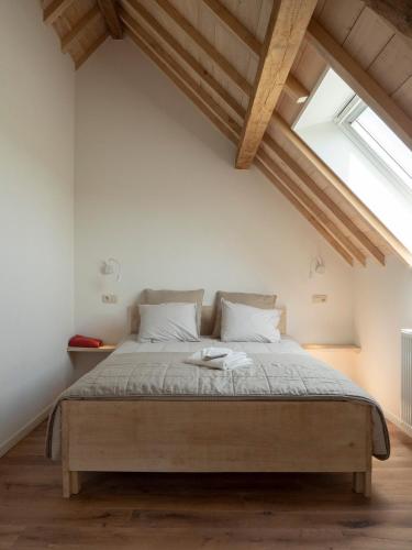 a bedroom with a large bed in a attic at Kompas gîte in Ellezelles