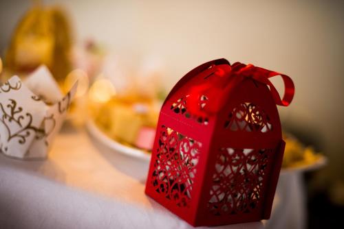 a red bird house on a counter with a bowl of food at Nairobi Safari Club by Swiss-Belhotel in Nairobi