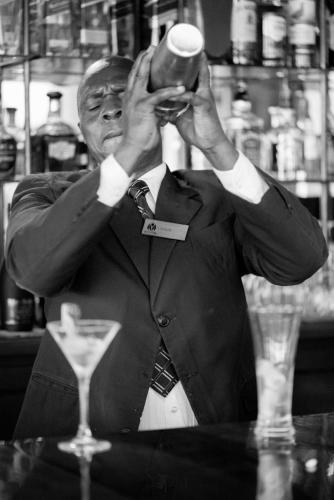 a man in a suit holding a glass of wine at Nairobi Safari Club by Swiss-Belhotel in Nairobi