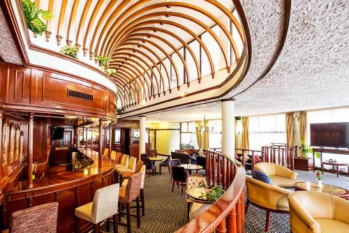 a restaurant with a bar and tables and chairs at Nairobi Safari Club by Swiss-Belhotel in Nairobi