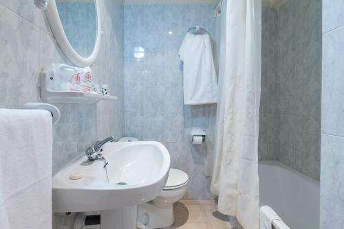 a bathroom with a sink and a toilet and a tub at Hotel Canadá in Tarragona