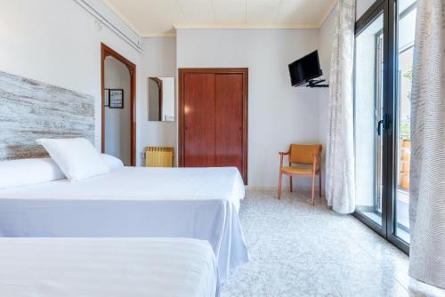 a hotel room with two beds and a television at Hotel Canadá in Tarragona