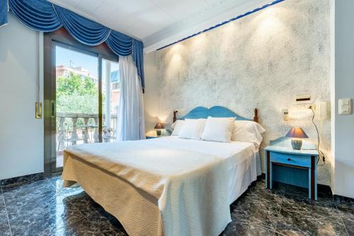 ein Schlafzimmer mit einem großen Bett und einem großen Fenster in der Unterkunft Hotel Canadá in Tarragona