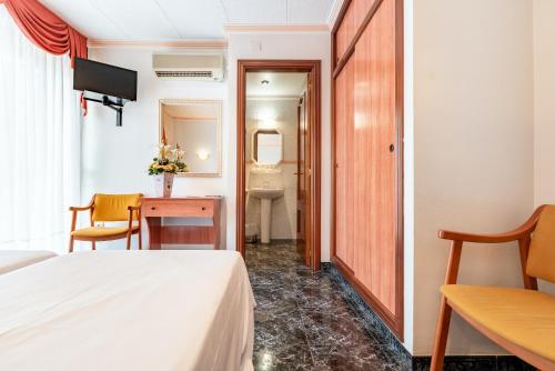 a hotel room with a bed and a bathroom at Hotel Canadá in Tarragona