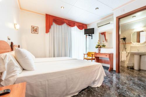 a hotel room with a bed and a desk at Hotel Canadá in Tarragona