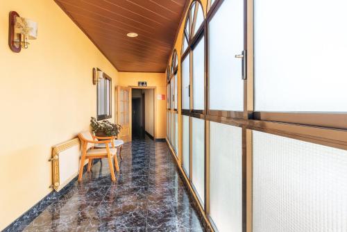 an empty hallway with a table and windows at Hotel Canadá in Tarragona