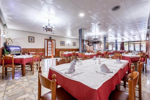 a dining room with tables and chairs with red tablecloths at Hotel Canadá in Tarragona