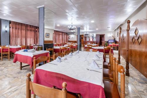 a dining room with a long table with red table cloth at Hotel Canadá in Tarragona