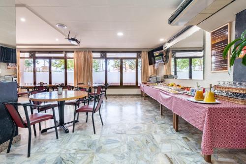 a dining room with tables and chairs and windows at Hotel Canadá in Tarragona