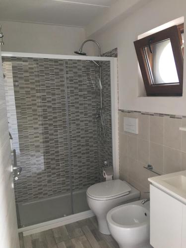 a bathroom with a shower and a toilet and a sink at Casale del Coccio in Scicli