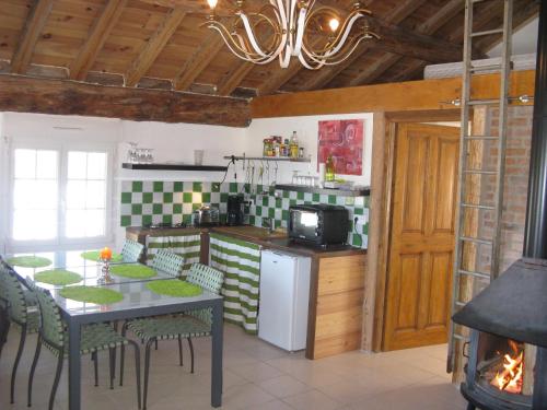 een keuken met een tafel en stoelen en een fornuis bij Chambre d'hôtes Chez Karine et Roland in Le Fied