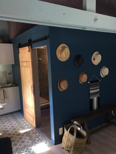 Eine blaue Wand mit einem Haufen Hüte drauf. in der Unterkunft L'atelier in Durbuy