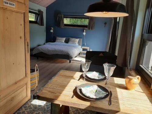 a living room with a table and a bed at L'atelier in Durbuy