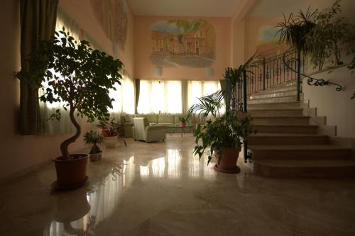 a hallway with stairs and potted plants in a building at Hotel La Grotte in San Donato Val di Comino