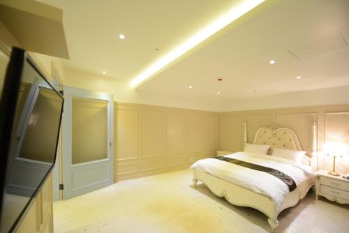 a bedroom with a large bed in a room at Dunsan Graytone Hotel in Daejeon