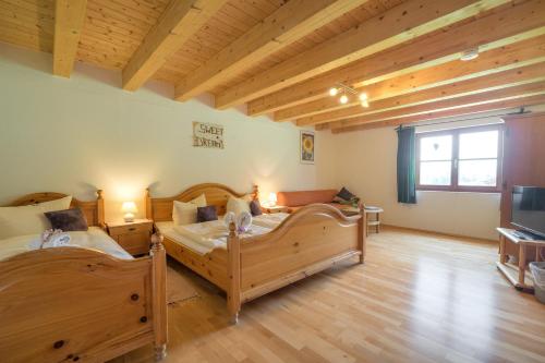 two beds in a large room with wooden ceilings at Berggasthof Riefenkopf in Oberstdorf