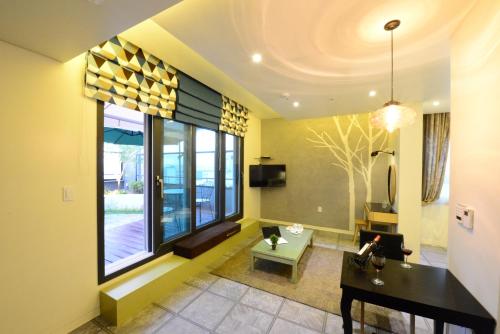 a living room with a table and a large window at Dunsan Graytone Hotel in Daejeon