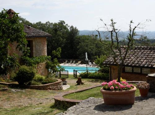 ogród z basenem i dom z kwiatami w obiekcie Agriturismo Il Caggio w mieście Sovicille