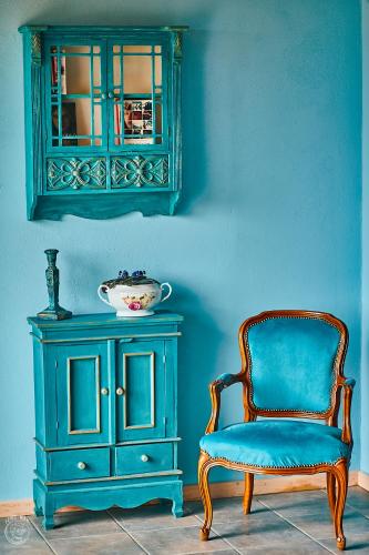 a blue wall with a chair and a dresser at Osada Chyże Jewki in Cisna