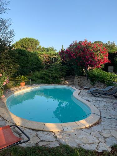 - une piscine dans une cour ornée de rochers et d'arbres dans l'établissement Lou Parpaillou Chambre double climatisée salle de bain privative, à Éguilles