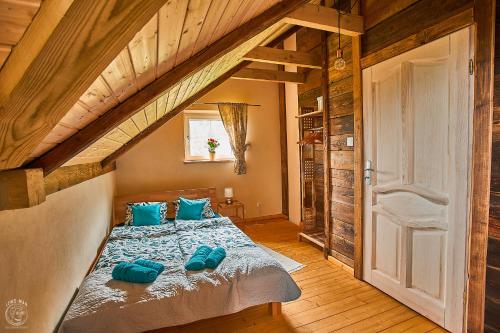 a bedroom with a bed with blue pillows on it at Osada Chyże Jewki in Cisna