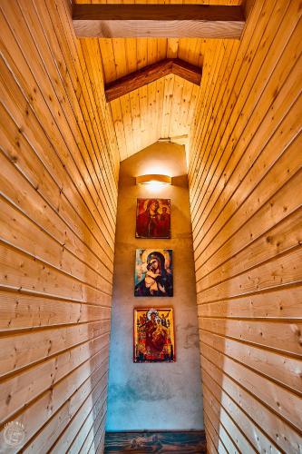 a wooden hallway with paintings on the wall at Osada Chyże Jewki in Cisna