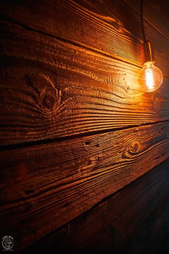a light bulb hanging on a wooden wall at Osada Chyże Jewki in Cisna