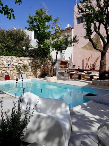 a swimming pool with two chairs and a building at The Manor - Old Town Rethymno, Crete in Rethymno Town