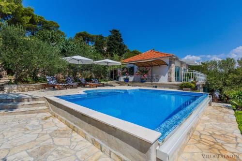 a swimming pool in a yard with a house at Villa Paladin - Spacious Villa with Pool near Garden Resort - 7 Min walk in Tisno