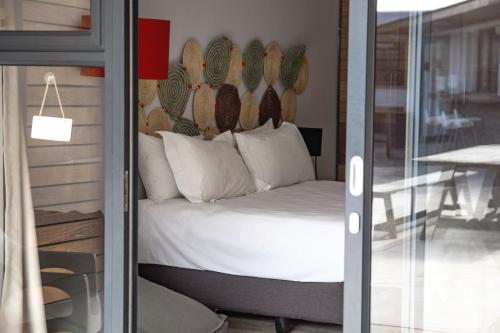 a bedroom with a bed with a headboard on the wall at Windtown Lagoon Hotel in Langebaan