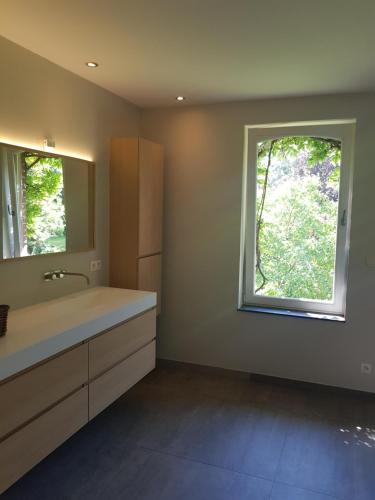 uma casa de banho com um grande lavatório e uma janela em Villa Germaine em Stratendries