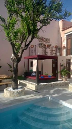 a house with a tree and a swimming pool at The Manor - Old Town Rethymno, Crete in Rethymno Town