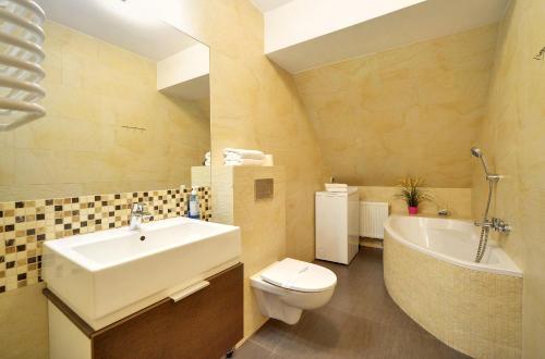 a bathroom with a sink and a toilet and a tub at Apartamenty EverySky - Leśny Dom 16 - 18 in Karpacz