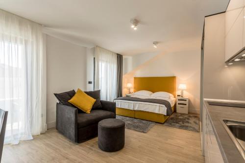 a bedroom with a bed and a couch and a chair at 2NIGHTSTUDIOS in Split