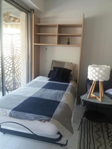 une chambre avec un lit, un bureau et une fenêtre dans l'établissement Studio Ste Sophie, à Cannes