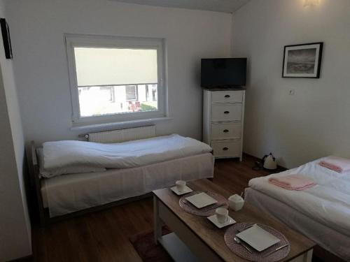 a room with two beds and a table and a window at Ustecka Przystan in Ustka