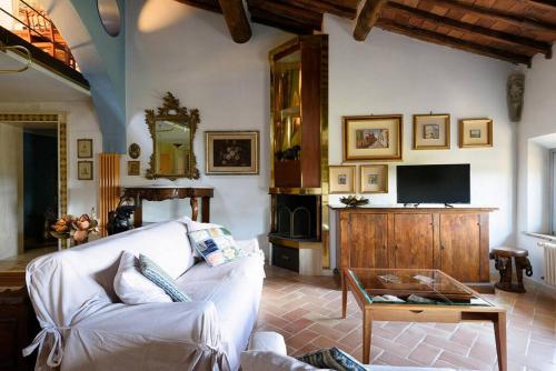 a living room with a white couch and a tv at Penthouse in Siena near Piazza del Campo in Siena