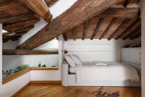 a bedroom with a bed and wooden ceilings at Penthouse in Siena near Piazza del Campo in Siena