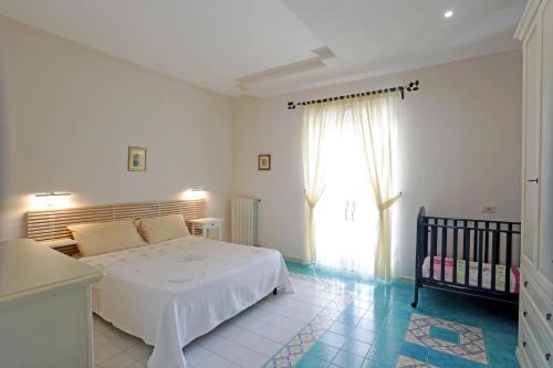伊斯皮卡的住宿－Eremo delle Grazie，一间卧室设有一张床、一个窗口和一张婴儿床