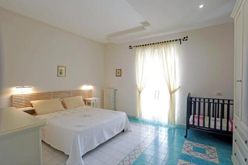 a bedroom with a bed and a window and a crib at Eremo delle Grazie in Ispica