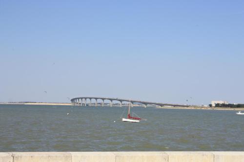 a boat in the water with a bridge in the background at COUP DE COEUR Studio in Rivedoux-Plage